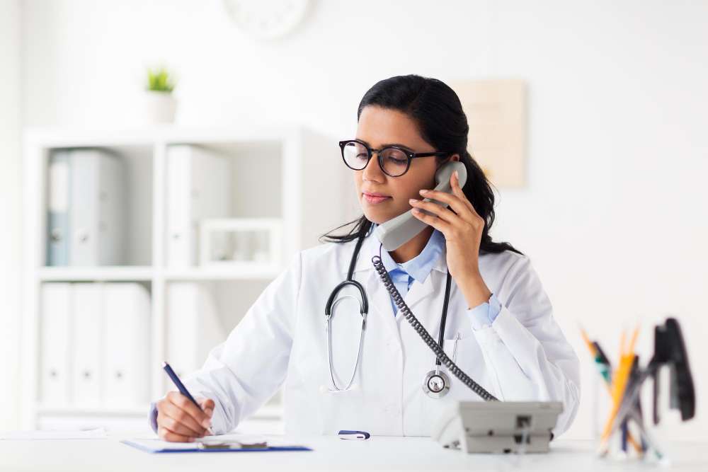 Female doctor on the phone at Roodepoort abortion clinic, providing information about abortion services.